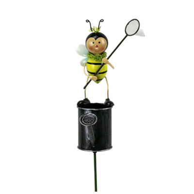 Garden metal bee with catching butterfly net standing on watering can fence stakes